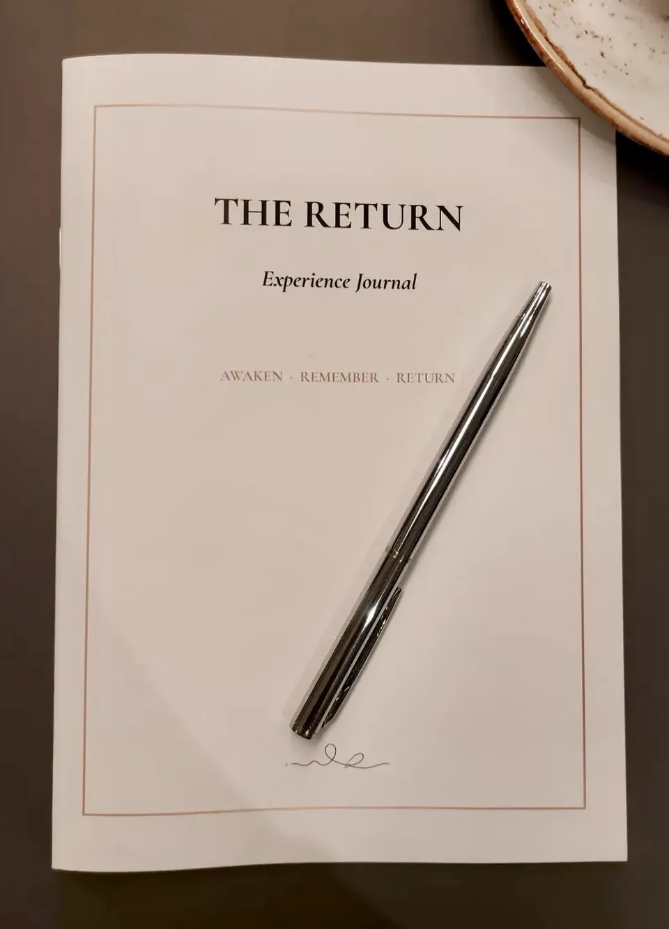 The Return Experience Journal with a silver pen